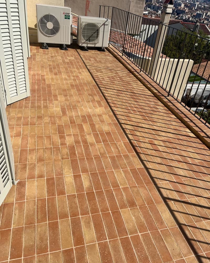 Balcon en terre cuite rénové, vue sur la ville.