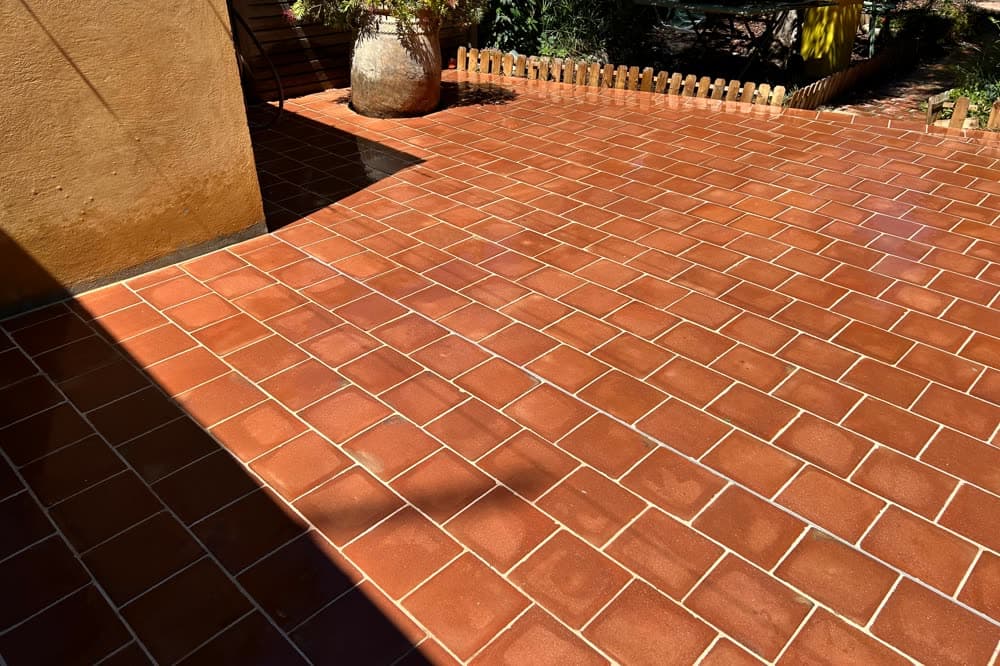 Terrasse en terre cuite traitée, avec une jarre, au soleil.